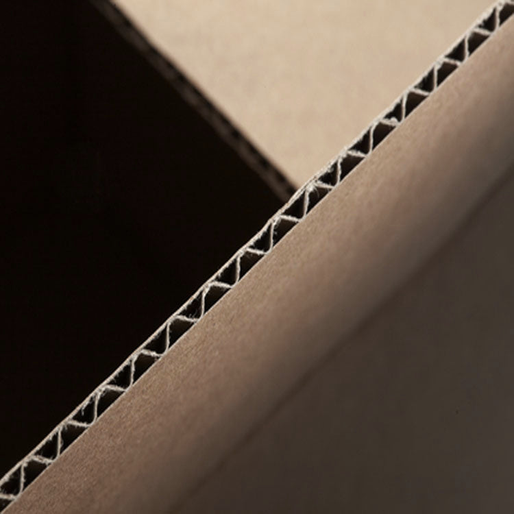 A close-up view of a single sheet of corrugated cardboard with visible honeycomb pattern slits